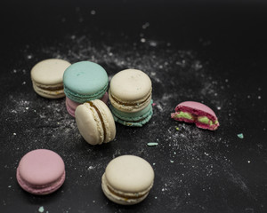colored macaroons on a black background