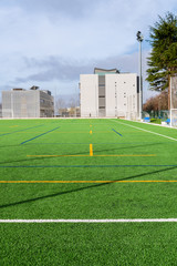 New Soccer camp with artificial turf and modern buildings at background