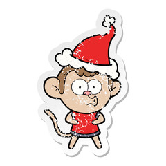 distressed sticker cartoon of a surprised monkey wearing santa hat