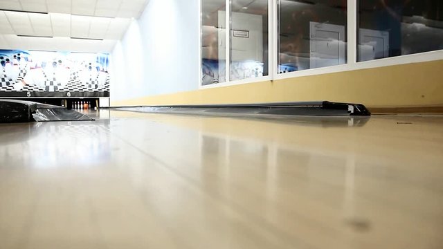 woman in leather pants throwing a bowling ball