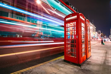 Gordijnen Lichtsporen van een dubbeldekkerbus naast de iconische telefooncel in Londen © kbarzycki