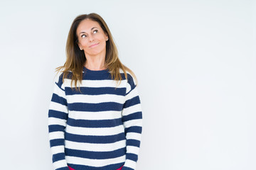 Fototapeta premium Beautiful middle age woman wearing navy sweater over isolated background smiling looking side and staring away thinking.