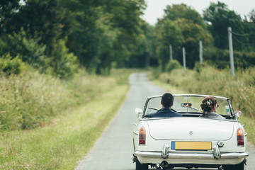 Couple strolling by convertible old car