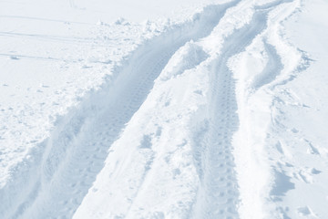 Fresh snow background texture. Winter background with snowflakes and snow mounds. Snow lumps. Road track and traces.