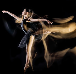 one caucasian young woman ballerina dancer dancing isolated on black background with  light...