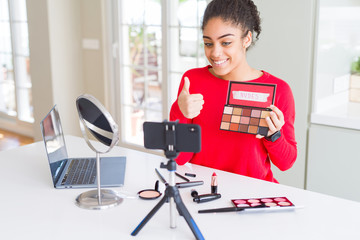 Young african american influencer woman recording make up tutorial happy with big smile doing ok...