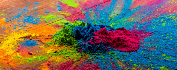Abstract colorful Happy Holi background. Color vibrant powder on wood. Dust colored splash texture....