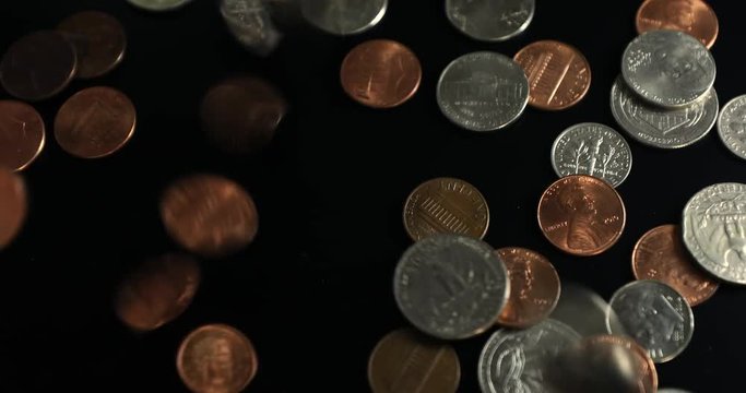 Coins falls on a black background. 