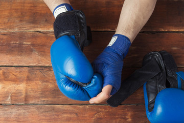 Men's hands in boxing bandages and boxing gloves on a wooden background. Concept preparation for...