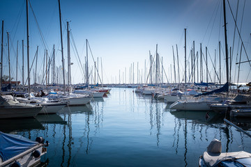 Fototapeta na wymiar Wooden pier with many boats and yachts in marina harbor