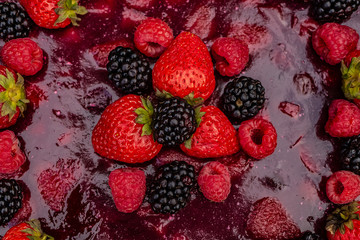 Beautiful and tasty cake decorated with berries of strawberry, blackberry and raspberry on a wooden background, close-up view from above, background.