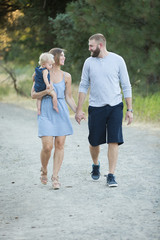 young family walking on dirt path