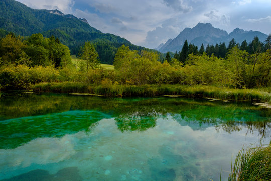 Scenic view of mountains reflecting in lake against cloudy sky