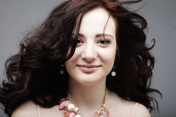 young woman with curly hair wearing pink dress