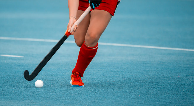 hockey player woman with ball in attack playing field hockey game