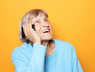 old woman wearing blue sweater  talking on cell phone