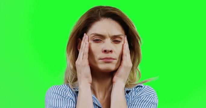 Portrait of the Caucasian woman having a bad headache spasm as being ill. Alpha channel. Green screen. Close up.