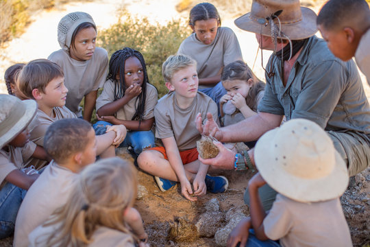 Children at a camp learning from guide