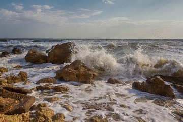 Waves stumble across rocks on the coast. Nature