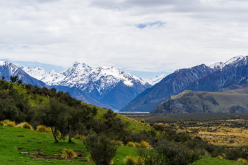 mountain landscape in the mountains, beautiful vast valley with mountains on the horizon, mountain peak covered by snow, during sunny with dramatic sky