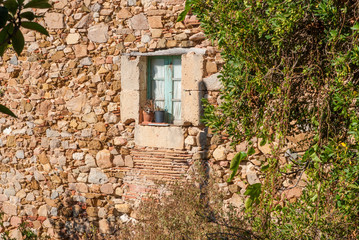 Wall and Antique window in the old town of Tossa de Mar, Spain.