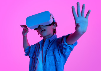 Boy using VR glasses in neon lights 