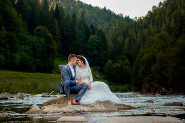 Happy newlyweds standing and smiling on the river . Honeymooners, photo for Valentine's Day