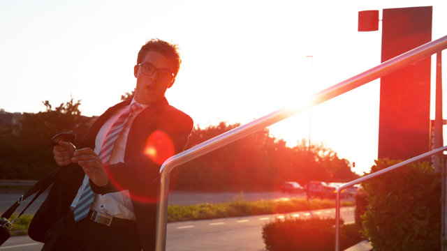 LENS FLARE: Business executive rushing to reach an evening meeting on time.