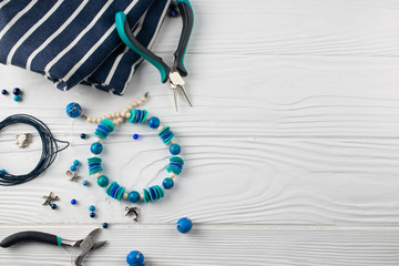Handmade turquoise bracelet, overhead flat lay composition with pliers, beads and tools
