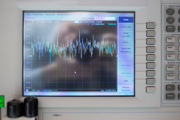 closeup view of oscilloscope with graph on lcd display and connected cords