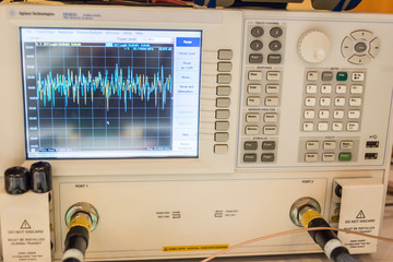 closeup view of oscilloscope with graph on lcd display and connected cords