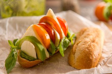 vegetarian italian food caprese sandwich with avocado cheese and pesto sauce
