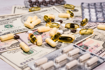 Pharmaceutical industry dollars money and drugs pills supplements health costs vitamin close up