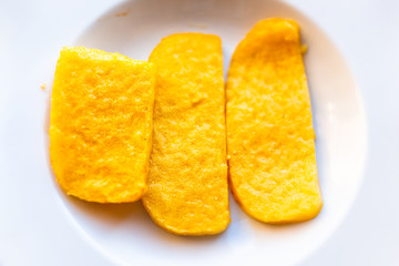 Polenta yellow orange corn cakes fried flat top view above down on white plate in restaurant appetizer golden color