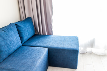 Modern living room sofa couch with window blinds curtains and closeup of minimalist blue couch in small apartment studio interior design and nobody in home