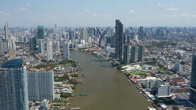 Aerial hyper lapse of Bangkok city and river. Sunny day with boats on the river
