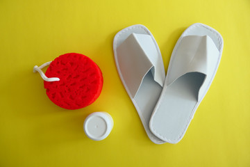 White Spa Slippers with a New Red Sponge and a Cream box isolated on Yellow Background