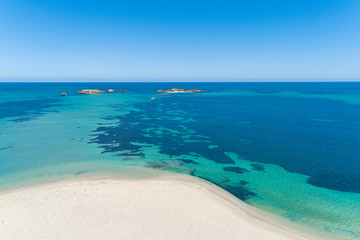 Fototapeta na wymiar Aerial view over sandy white beach in summer with stunning turquoise blue ocean