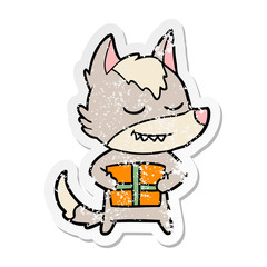 distressed sticker of a friendly cartoon wolf carrying christmas present