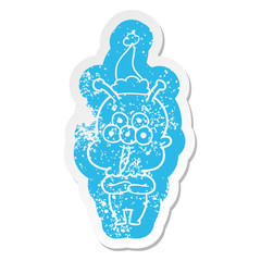 happy cartoon distressed sticker of a alien wearing santa hat