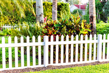 White beach wooden wood architecture picket fence of house in front porch yard garden with green...