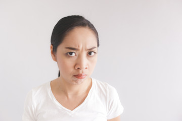 Sulk and grumpy face expression of woman in white t-shirt. Concept of offended peevish and sulky.