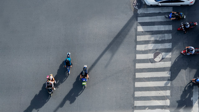 Top View Aerial Photo Of Motorcycle Driving Pass Pedestrian Crosswalk In Traffic Road With Light And Shadow Silhouette