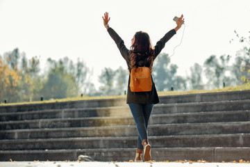 Full length of carefree woman with raised arms enjoying in her freedom.