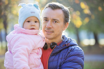 Caucasian man and baby daughter in autumn park