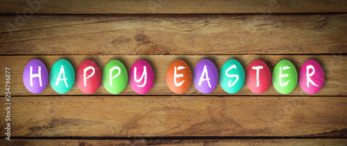 colored eggs with letters forming the word easter on wooden background