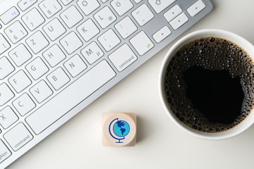 Würfel mit Welt-Sybol vor Tastatur