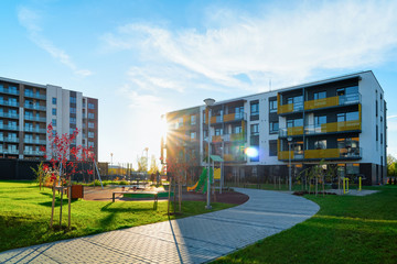 Apartment residential house facade architecture with kids playground sun light