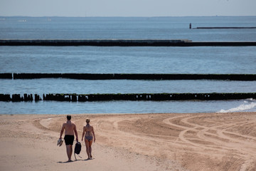 A couple walks along a sandy beach