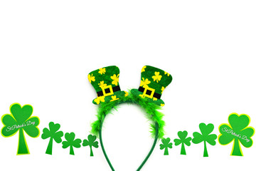 St Patricks day, festive leprechaun hat on headband and green Shamrocks on white background